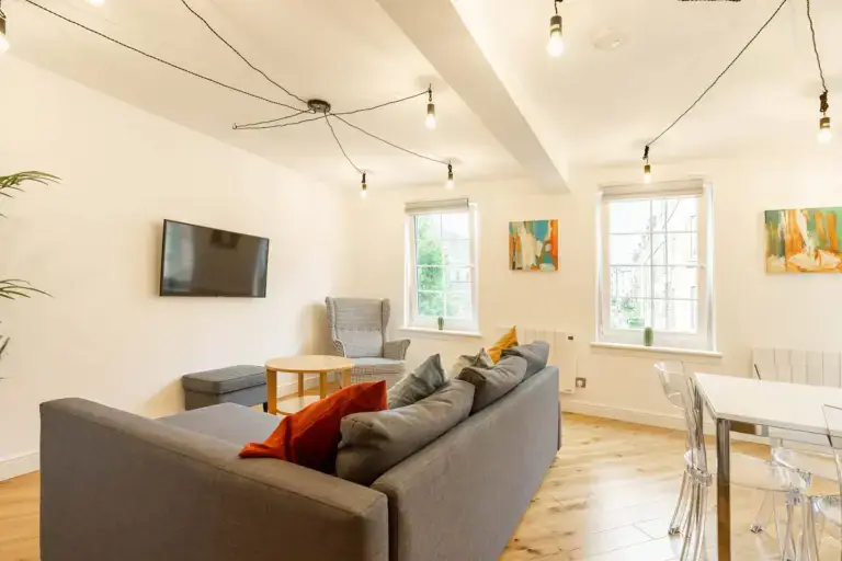 Open-plan living and dining room with a grey corner sofa