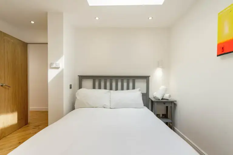 Double bedroom with a grey headboard and white bedding