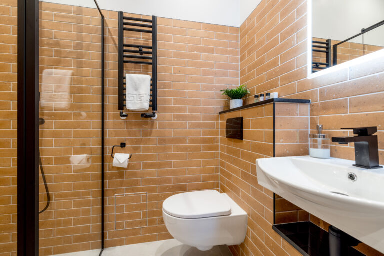 Ochre-tiled bathroom with a mirror, basin and towel radiator