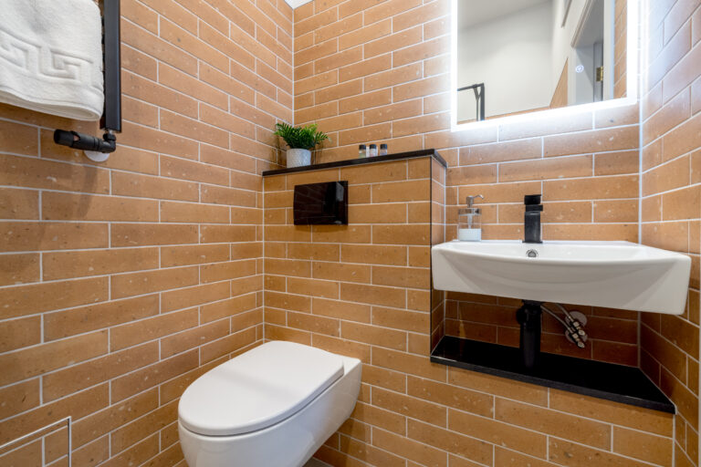 Bathroom with ochre tiles, a white basin and toilet