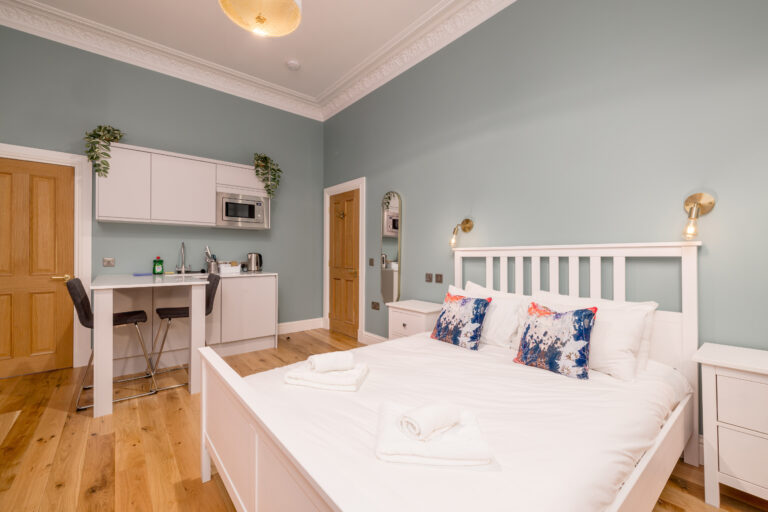 Double bed beside a kitchenette in an Edinburgh studio