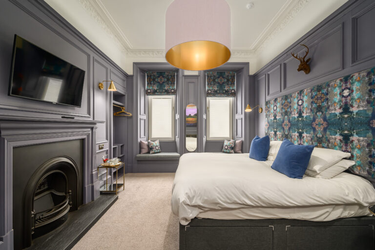Double bedroom with blue cushions and a fireplace