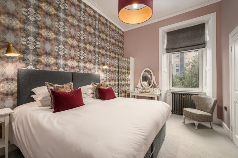 Twin bedroom with a dressing table and patterned feature wall