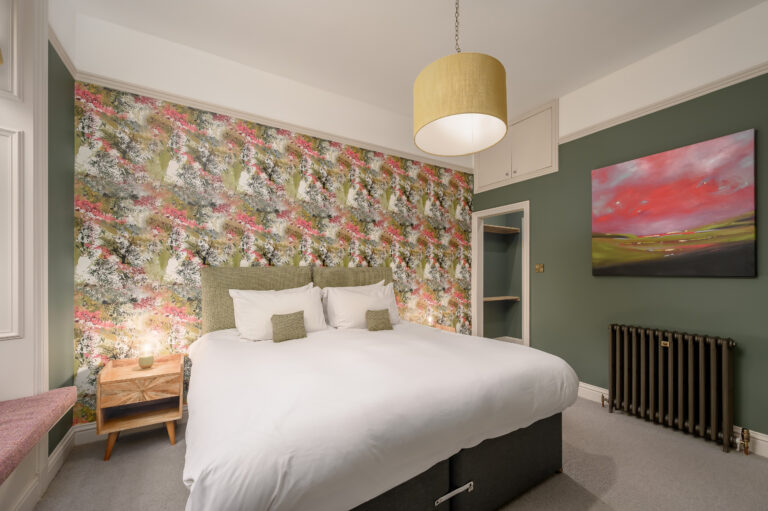 Twin bedroom with green walls and a yellow lampshade