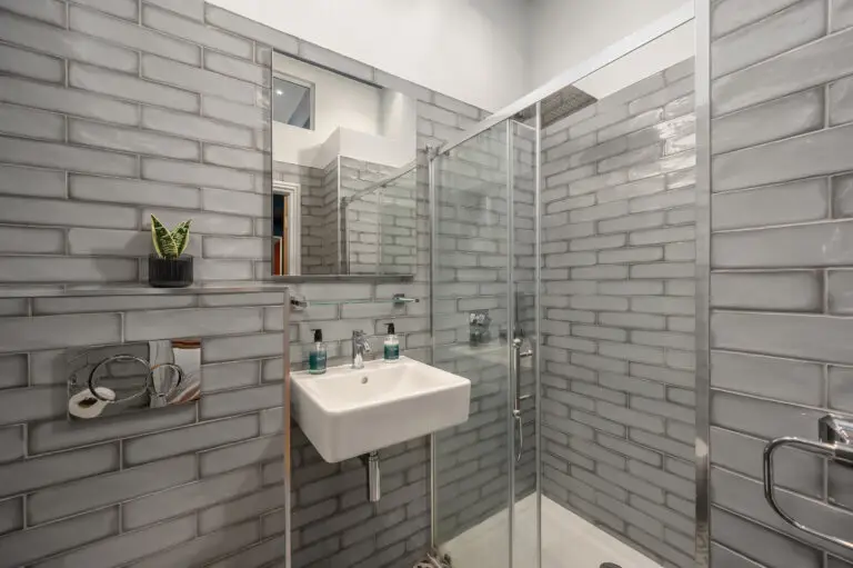 Grey-tiled shower room with a rectangular basin and mirror
