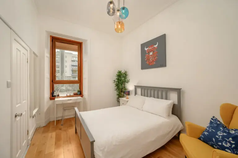 Double bed beside a tall window in an Edinburgh guest room