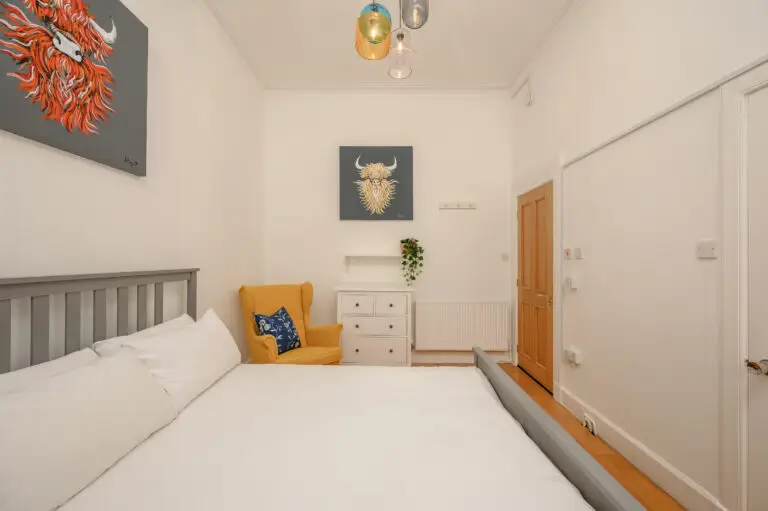 Double bedroom with a yellow chair and animal wall art