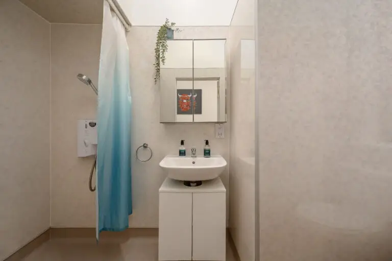 Shower room with a blue shower curtain and white basin