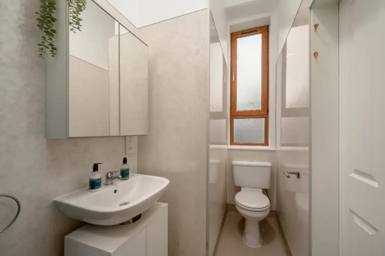 Compact shower room with a basin, toilet and frosted window