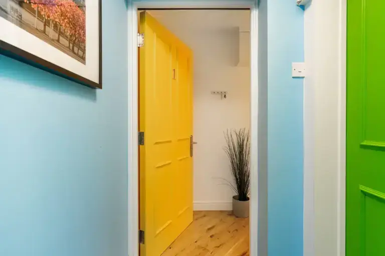 View through a green doorway towards a yellow apartment door