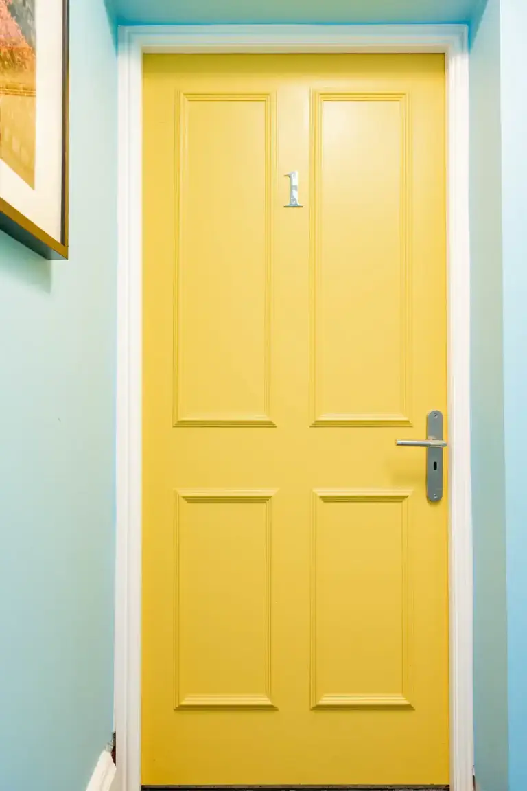 Yellow interior door framed by blue walls