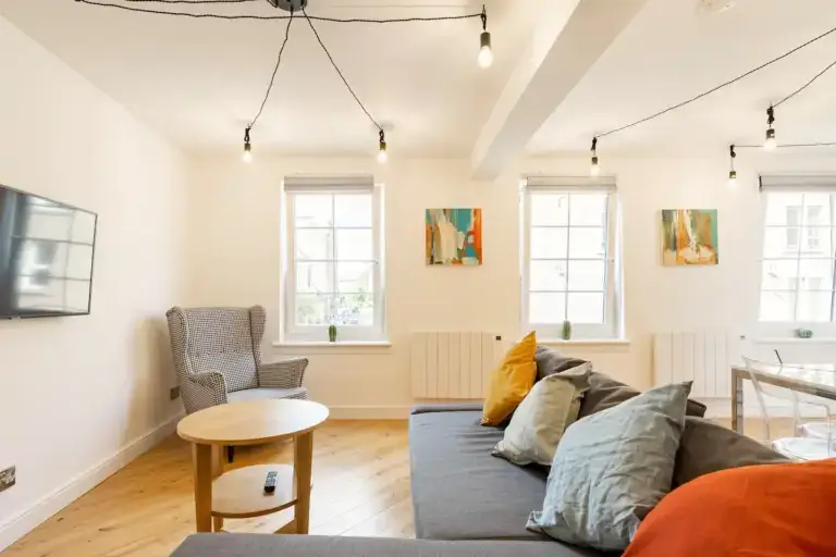 Apartment lounge with a grey sofa, armchair and coffee table