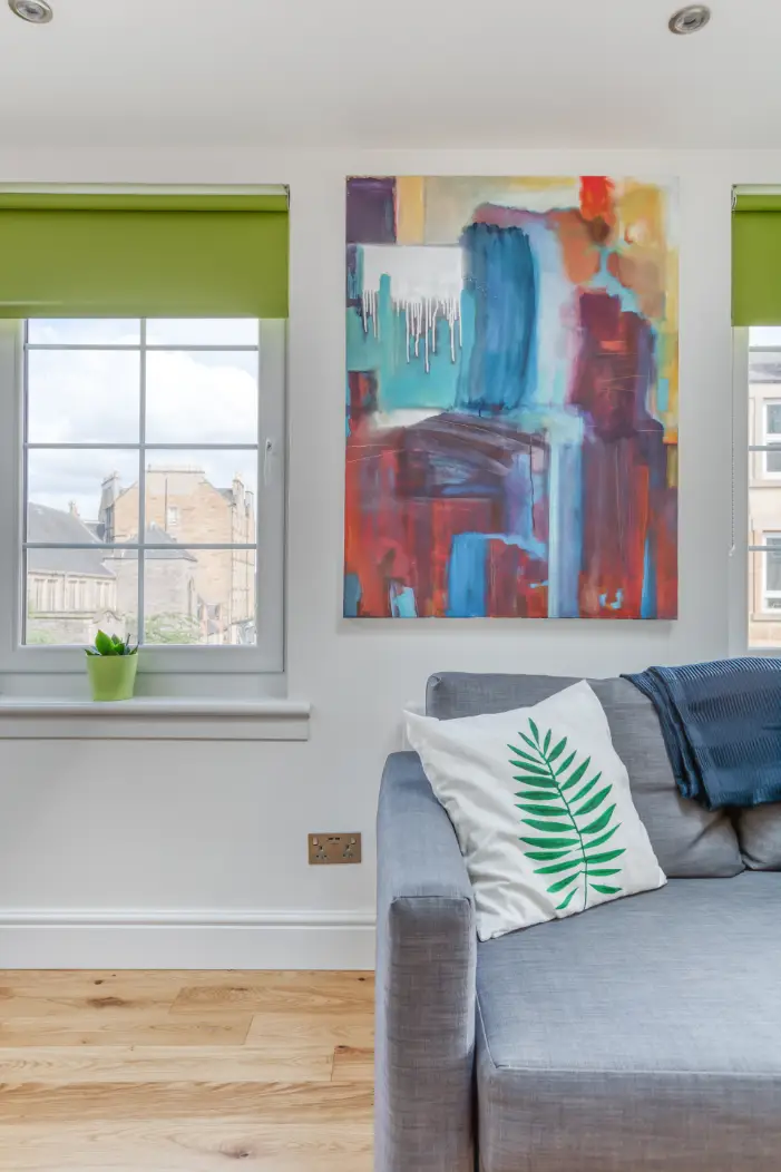 Colourful wall art above an apartment sofa