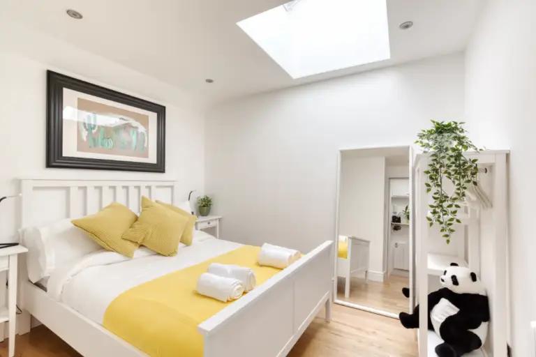 Double bedroom with yellow cushions and a skylight