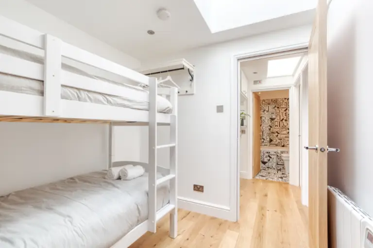 White bunk beds beside the bedroom doorway