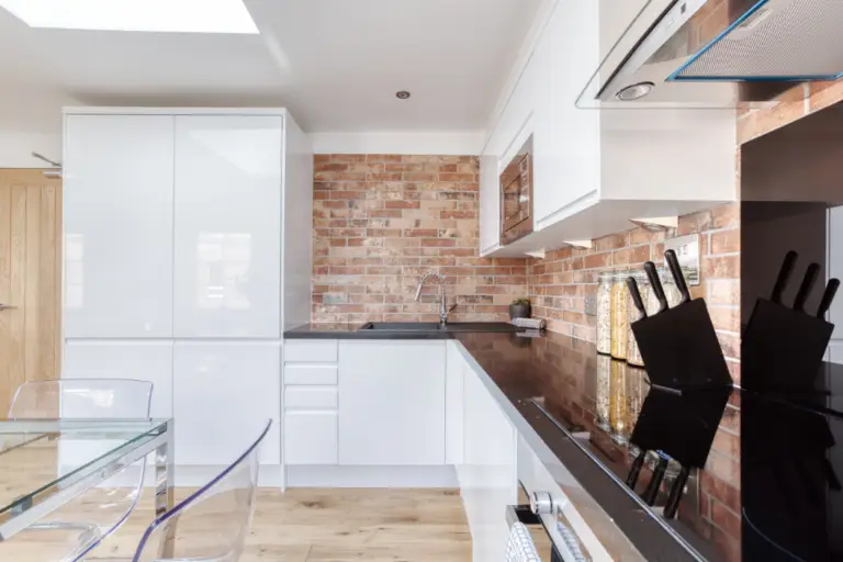 Apartment kitchen with white cupboards and dark worktops