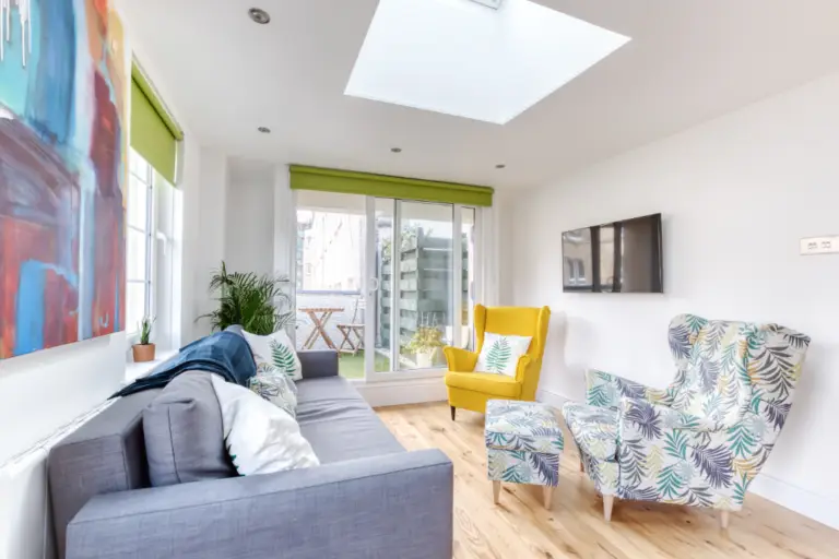 Grey sofa and patterned armchairs in a bright apartment living room
