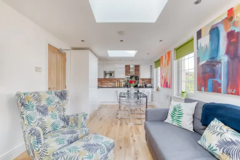 Living area leading to a white fitted kitchen in a Caledonian apartment