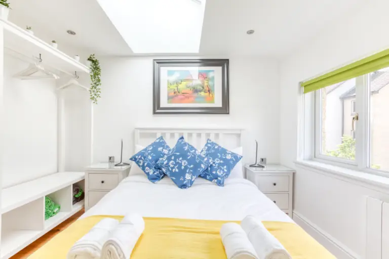 Double bed beneath a skylight with blue patterned cushions