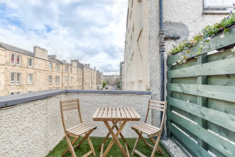 Private terrace with a wooden table overlooking Edinburgh buildings