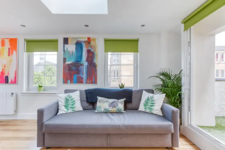 Grey sofa beneath colourful artwork in a Caledonian apartment