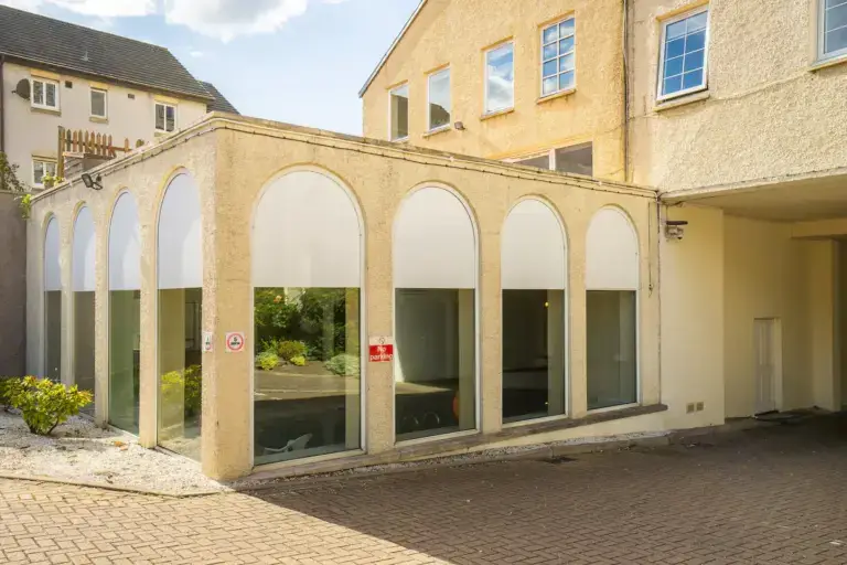 Arched entrance beside a stone apartment building