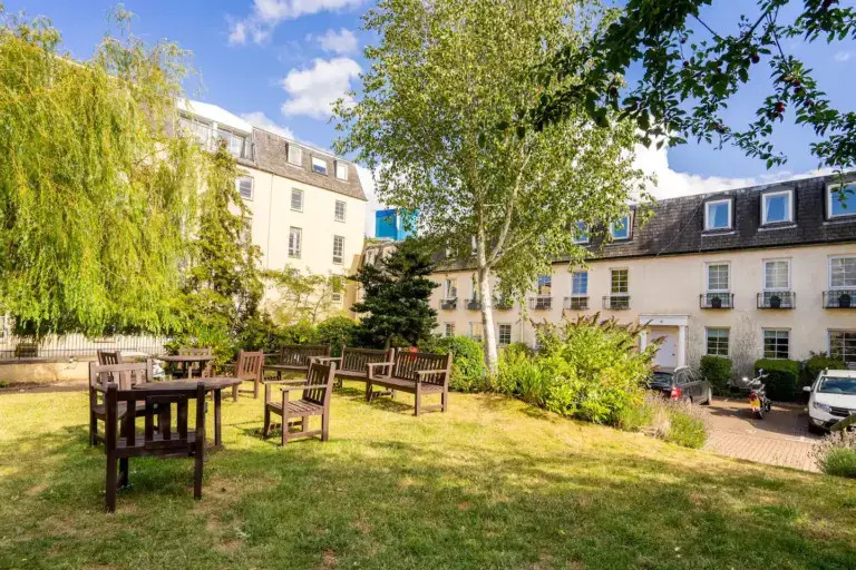 Communal garden with outdoor tables and mature trees