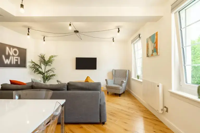 Bright open-plan apartment living room with a grey corner sofa