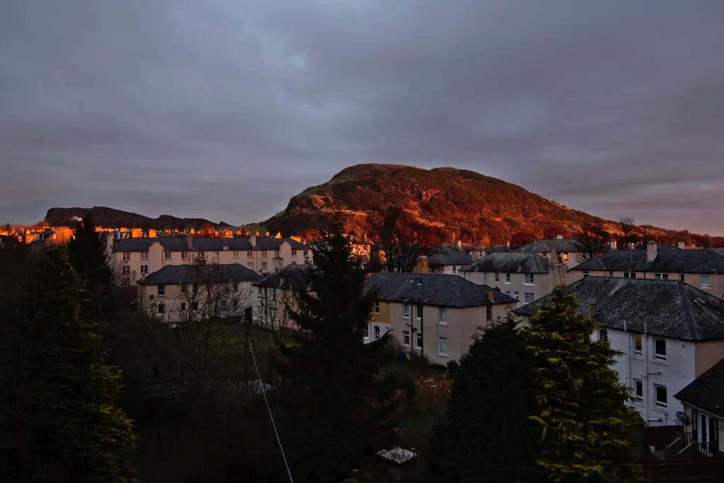 Arthur’s Seat in golden morning light above Edinburgh rooftops