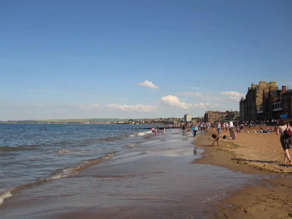 Visitors enjoying the sand and shoreline at Portobello Beach in Edinburgh
